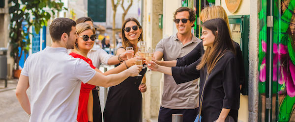 Group outside in Lisbon toasting with wine