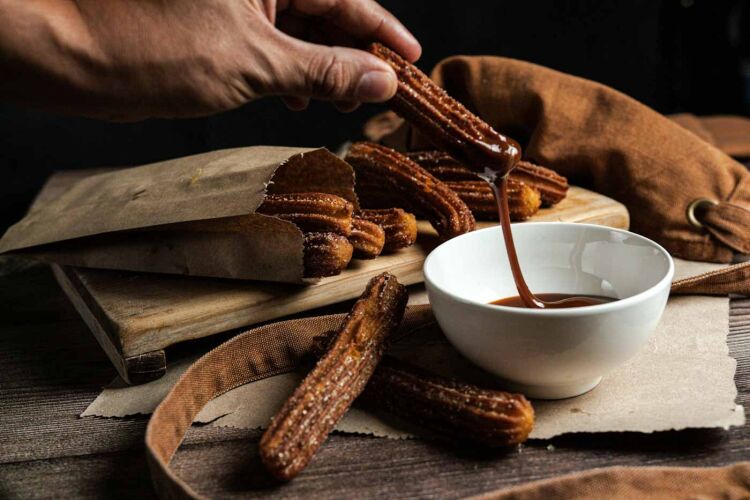 Person_dipping_churros_into_sauce_Barcelona